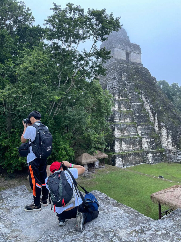 ©Juan Ixbalán/Fotokids2024 The boys taking a break and photographing the pyramids of Tikal